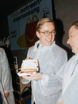 Philipp Amthor präsentiert im Schutzkittel einen selbst zubereiteten McRib bei McDonald’s in Zimmern ob Rottweil, fotografiert für DER SPIEGEL.